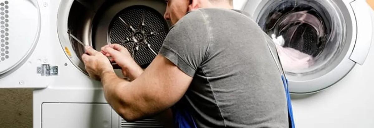 Dryer repair technician fixing a clothes dryer drum in Tucson, AZ