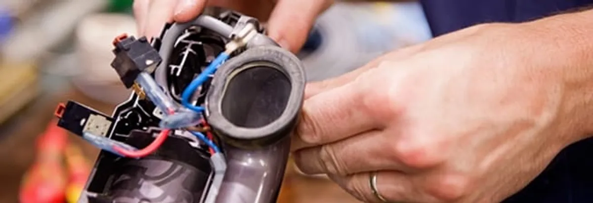 Vacuum repair technician reconnecting wiring and components in Tucson, AZ