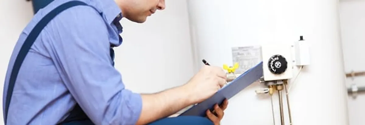 Water heater repair technician inspecting the unit and recording service notes in Tucson, AZ