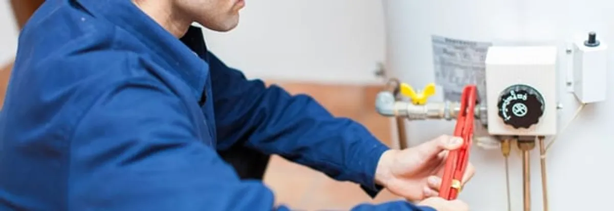 Water heater repair technician adjusting the temperature control and gas valve in Tucson, AZ